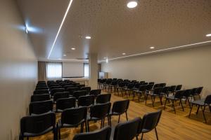 an empty room with black chairs and a white wall at Avenida de Fatima in Fátima