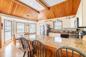a kitchen with a large counter with chairs in it at Shore is Fun - Duck, Poteskeet, Beach 480 Yds, 3 Min. Walk to Downtown, Pool, Hot Tub, YR Flex in Duck