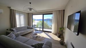 ein Wohnzimmer mit zwei Sofas und einem großen Fenster in der Unterkunft Ansira Fethiye in Fethiye