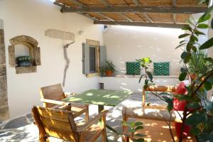 a patio with a table and chairs in a room at Rouga - bright terrace studio in Aroniadika