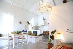 a room with a couch and a table and chairs at Rouga - bright terrace studio in Aroniadika +9 photos