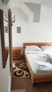 a bedroom with a bed and a rug at Pensiunea Iris in Săcele
