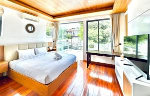 a bedroom with a bed with a cat sitting on it at Anara Pool Villa 3 Bedrooms in Nathon Bay