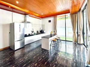 a kitchen with a refrigerator and a counter at Anara Pool Villa 3 Bedrooms in Nathon Bay