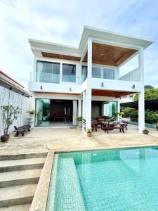 a house with a swimming pool in front of a house at Anara Pool Villa 3 Bedrooms in Nathon Bay