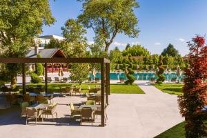 a patio with tables and chairs next to a pool at NG Enjoy in Sapanca