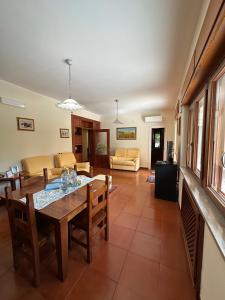 a dining room and living room with a table and chairs at Villa Chiara in Piscopio