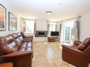a living room with leather furniture and a fireplace at Mill Lodge in Brisley