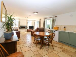 a kitchen and living room with a table and chairs at Mill Lodge in Brisley