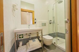 a bathroom with a sink and a toilet and a shower at Casa da Sé by PURUS in Coimbra +30 photos