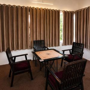 a conference room with a table and chairs and curtains at Stone Rose Vista in Kanatal