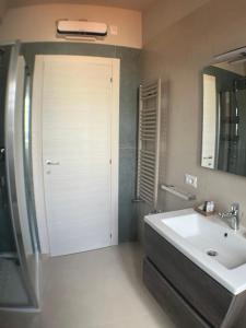 a bathroom with a white sink and a door at Harmony Suite in Aprilia +20 photos
