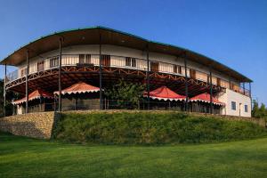 a large building with red umbrellas in front of it at Stone Rose Vista in Kanatal
