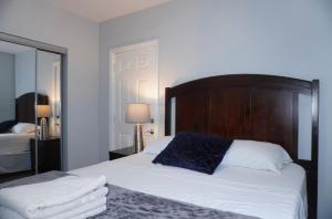 a bedroom with a bed with a wooden headboard and a mirror at West New York room 15 in West New York