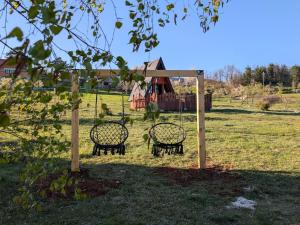 a swing set in a park with a playground at A Pine vikendica u srcu Zapadne Srbije in Nova Varoš