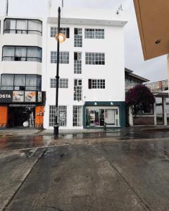 a white building with a street light in front of it at Hotel Posada Centro Atlacomulco Cuarto Barra in Atlacomulco de Fabela