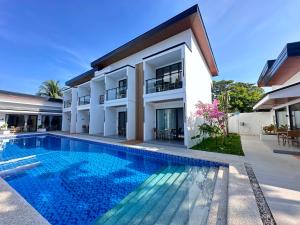 a villa with a swimming pool in front of a house at Diver's home resort in Panglao Island
