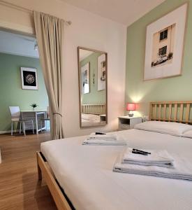a bedroom with two beds and a mirror at Al Glicine Apartments in Lazise