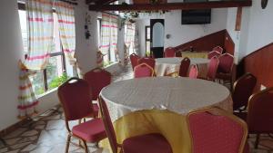 a dining room with tables and chairs and windows at Pensiunea Iris in Săcele