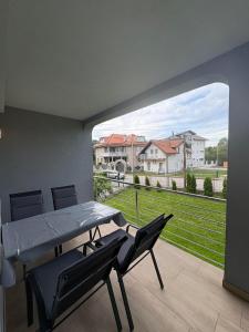 a dining room with a table and chairs and a large window at Vila Ziki in Sarajevo
