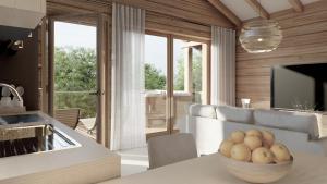 a kitchen and living room with a bowl of fruit on a table at Sky Chalets Bühlertal in Bühlertann