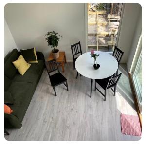 a living room with a couch and a table with chairs at Seabreeze Pine Retreat in Åhus