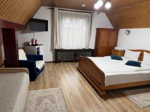 a bedroom with two beds and a television in it at Pensiunea Eugenia in Bran