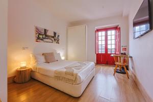 a bedroom with a bed and a red door at Casa da Sé by PURUS in Coimbra