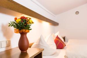 a vase with flowers on a table in a room at Hotel Sonnleiten in Reit im Winkl