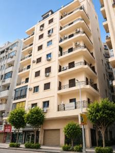 a tall apartment building with trees in front of it at Cairo Center in Cairo