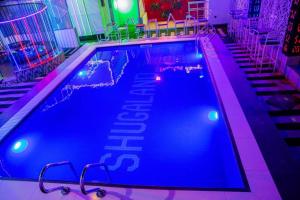 a large swimming pool with lights in a room at Shugaland hotel and lounge in Ibadan