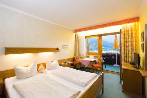 a hotel room with a bed and a table and a window at Hotel Sonnleiten in Reit im Winkl