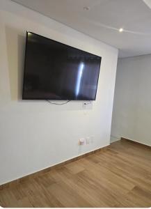 a flat screen tv hanging on a white wall at Casa De Valentina in Tiradentes