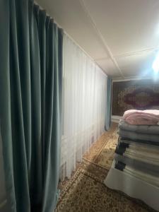 a room with a bed and a curtain at Бекбол in Sovetskoye