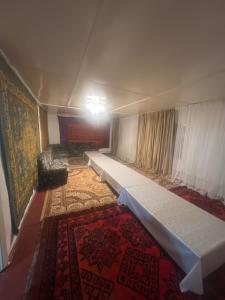 a large room with a couch and a carpet at Бекбол in Sovetskoye