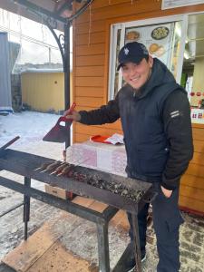 a man is standing next to a table with hot dogs at Бекбол in Sovetskoye