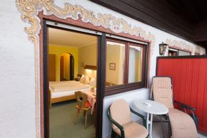 a room with a bed and a table and chairs at Hotel Sonnleiten in Reit im Winkl