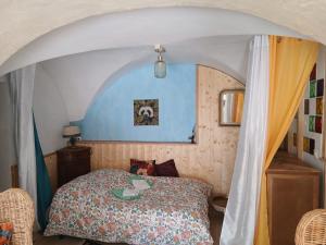 a bedroom with a bed with a blue wall at Gite Le Romanesque in Clelles
