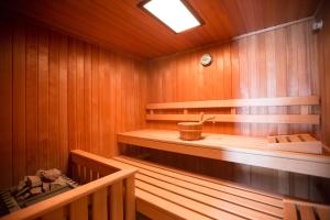a sauna with wooden walls and wooden shelves and a clock at Deva Hotel Sonnleiten in Reit im Winkl