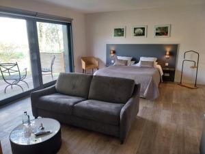 a living room with a bed and a couch at Le Petit Coq aux Champs - Teritoria in Campigny +33 photos