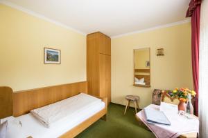 a hotel room with a bed and a desk with a laptop at Hotel Sonnleiten in Reit im Winkl