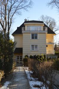une maison jaune avec une allée devant elle dans l'établissement Rosehill Side Apartment, à Budapest