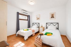 two beds in a room with white walls and wood floors at Villa Asomada in La Asomada +22 photos
