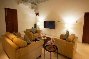 a living room with two couches and a tv at Sudu Appu Villa Beruwala in Beruwala