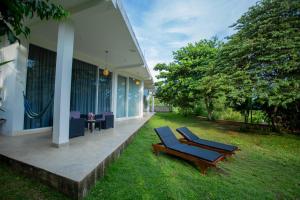 a couple of lounge chairs on a porch of a house at Sudu Appu Villa Beruwala in Beruwala