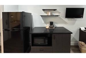a kitchen with a black refrigerator and a microwave at Studio 6 Suites Hesperia CA West Main Street I 15 in Hesperia