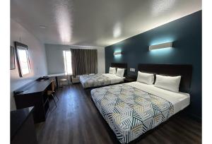 a hotel room with two beds and a desk at Studio 6 Suites Hesperia CA West Main Street I 15 in Hesperia +28 photos