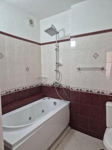 a bathroom with a tub and a toilet at Хотел М in Asenovgrad