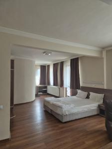 a large bedroom with a bed and a couch at Хотел М in Asenovgrad