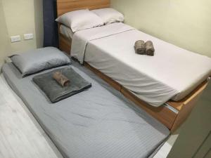 two beds in a room with shoes on them at Cityscape Grand Tower Cebu - 2 Bedrooms with Balcony Close to Ayala Mall - New Condo in Cebu City